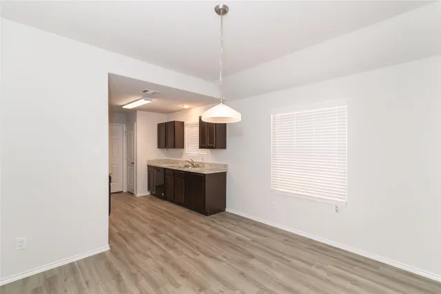 a kitchen with stainless steel appliances granite countertop a sink and a wooden floor