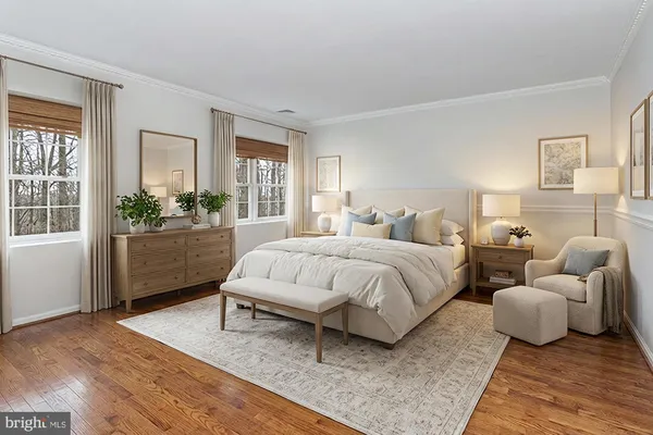 a spacious bedroom with a bed and wooden floor