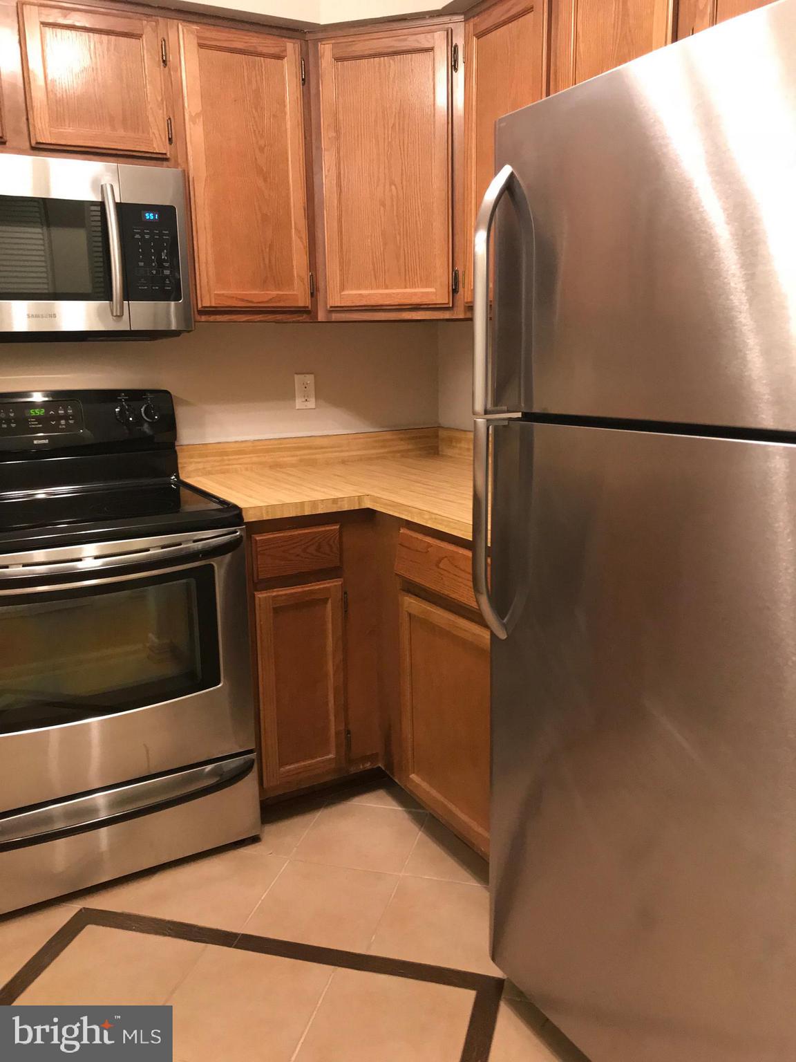 7702 Lexton Place, Unit 65 Springfield, VA 22152 - Photo 11 of 24 a kitchen with stainless steel appliances granite countertop a refrigerator and a stove top oven