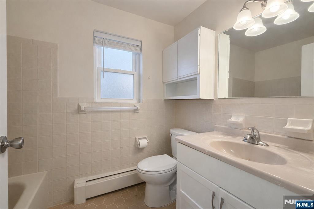55 Knox Terrace, Unit 1A Wayne, NJ 07470 - Photo 9 of 9 a bathroom with a sink a toilet and a mirror