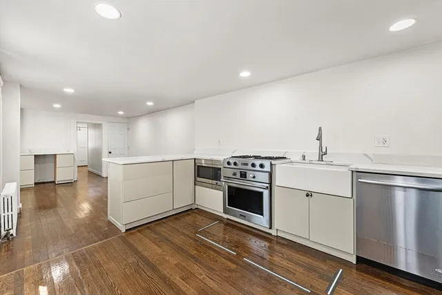 a kitchen with a stove top oven and white cabinets