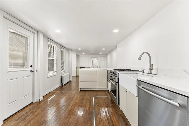 a kitchen with a sink and wooden floor