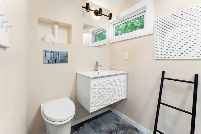 a bathroom with a sink toilet and window