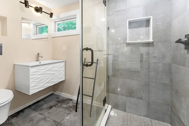 a bathroom with a sink a toilet and shower