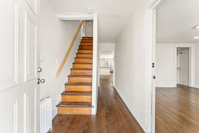 a view of a hallway with wooden floor and entryway