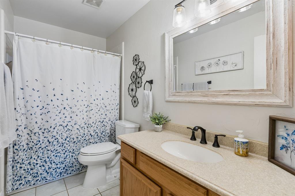 915 Rutgers Court Allen, TX 75002 - Photo 25 of 39 The secondary bath has framed mirror, updated light fixture and tub with shower.