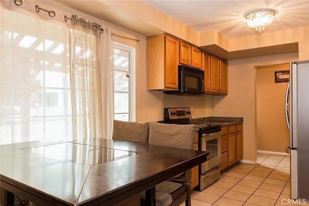 38603 Sage Tree Street Palmdale, CA 93551 - Photo 7 of 17 a kitchen with stainless steel appliances granite countertop a stove a sink and a refrigerator