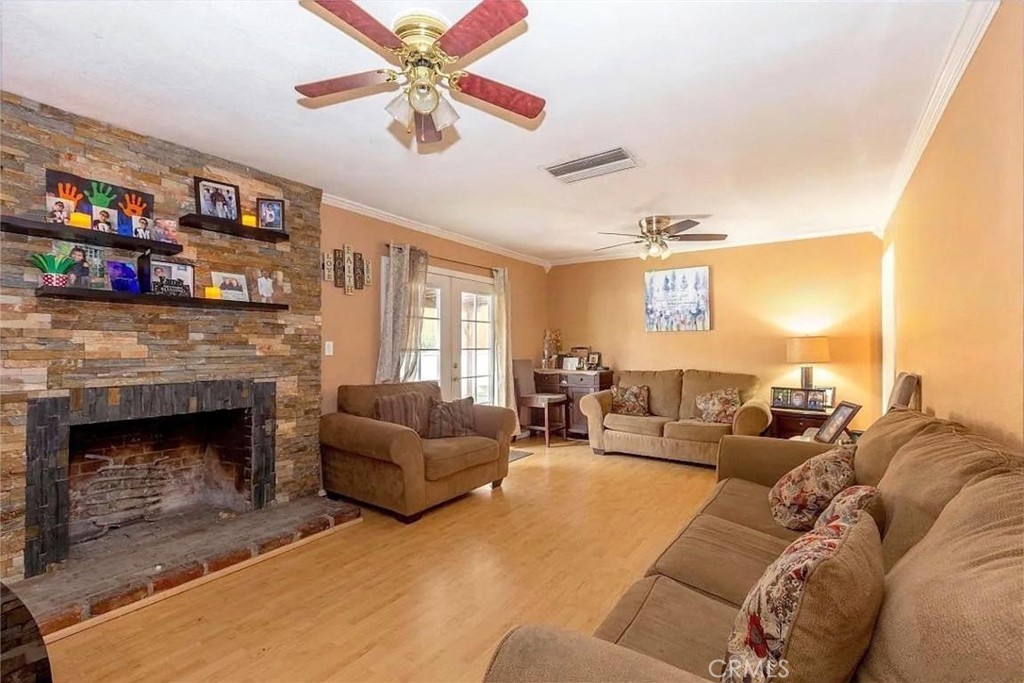 38603 Sage Tree Street Palmdale, CA 93551 - Photo 9 of 17 a living room with furniture a fireplace and a flat screen tv