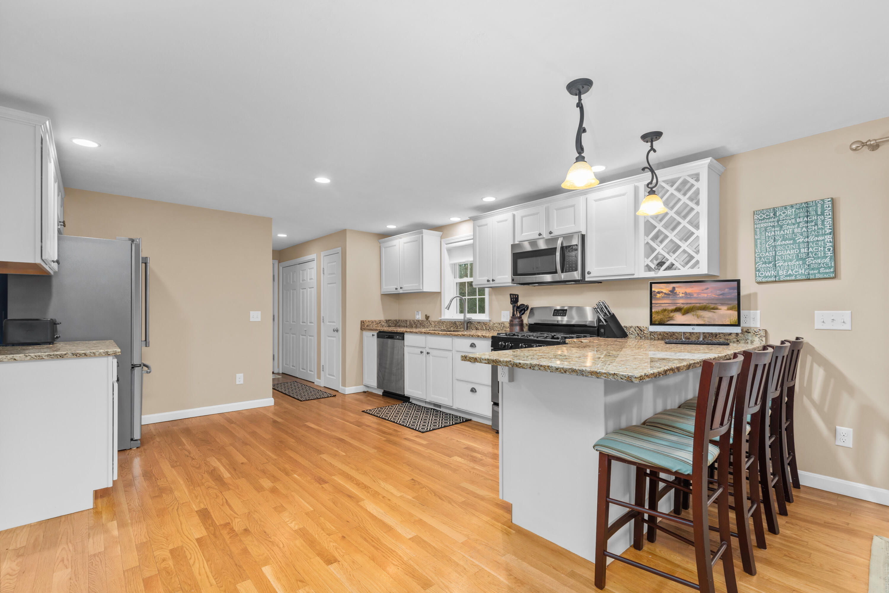 5 Baker Road Wellfleet, MA 02667 - Photo 6 of 30 a open kitchen with stainless steel appliances granite countertop a stove top oven a refrigerator a sink dishwasher a dining table and chairs with wooden floor