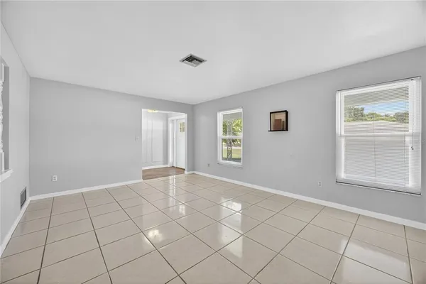 a view of an empty room with window and cabinet