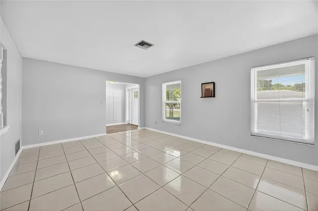 a view of an empty room with window and cabinet