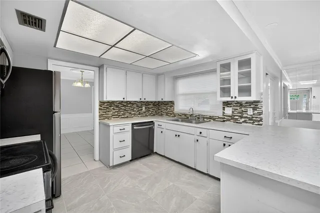 a kitchen with granite countertop white cabinets and stainless steel appliances