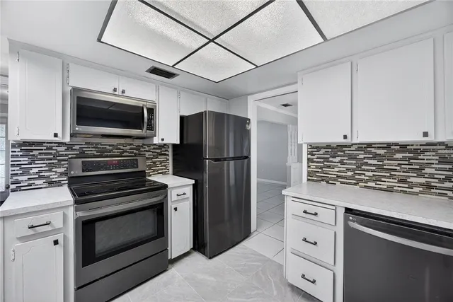 a kitchen with granite countertop a stove and a refrigerator
