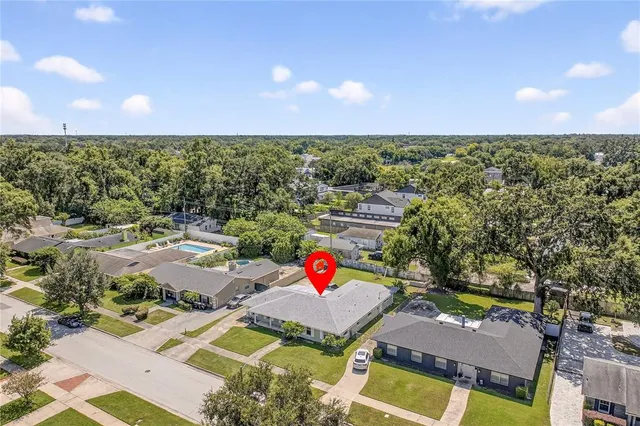 an aerial view of residential houses with outdoor space and trees