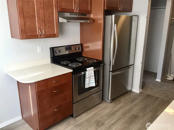 a kitchen with stainless steel appliances granite countertop a refrigerator a stove and a microwave