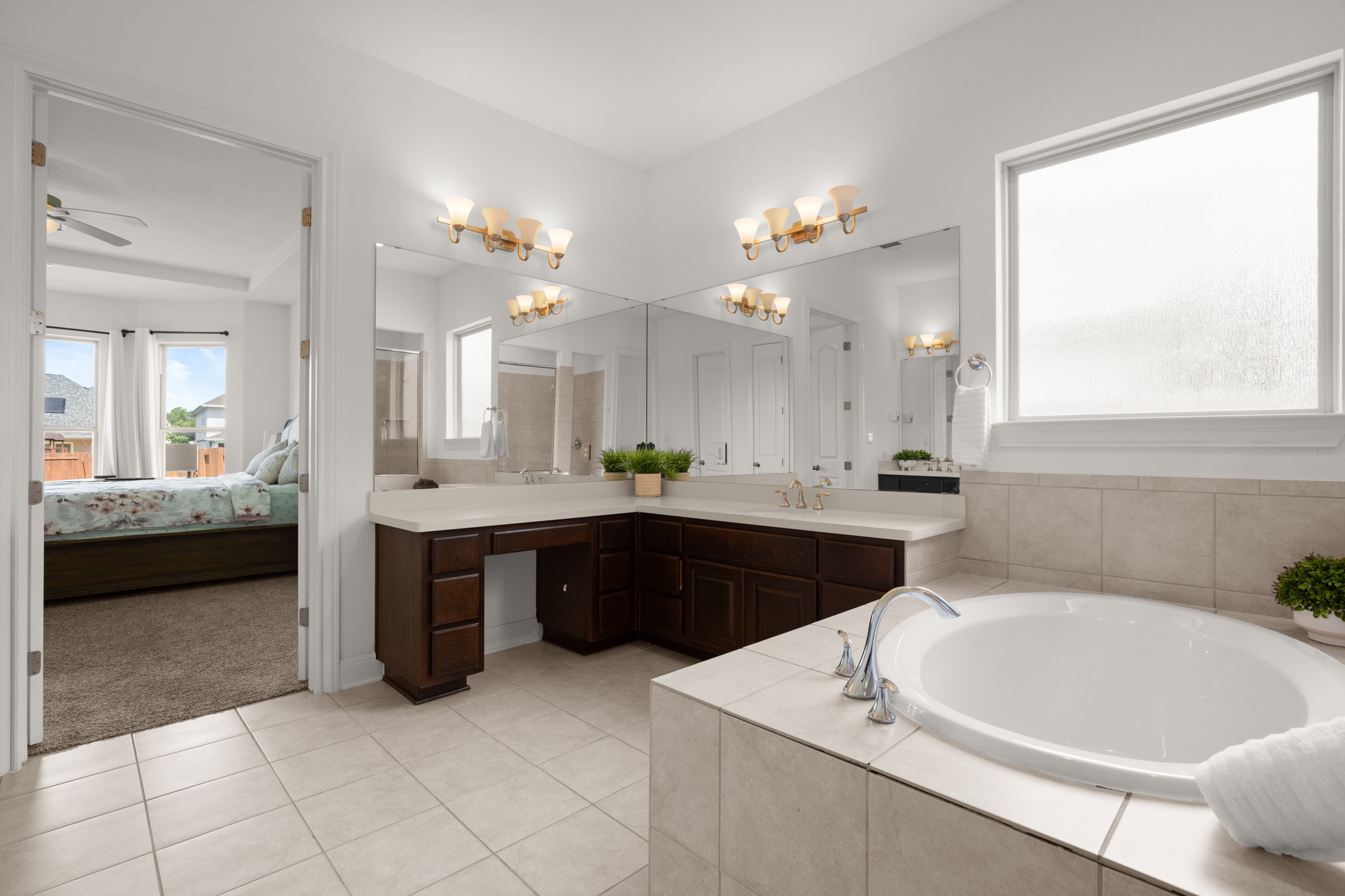 2817 Gatlin Cove Leander, TX 78641 - Photo 20 of 40 The spacious primary ensuite bath is your daily spa getaway with two separate vanities, one with dressing table seating, plus a walk-in closet.