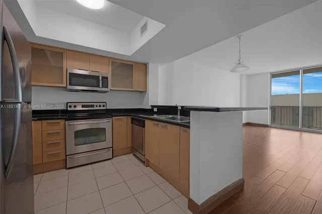 a kitchen with stainless steel appliances granite countertop a refrigerator and a stove top oven