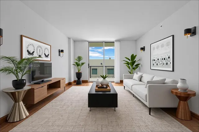 a living room with furniture a flat screen tv and a potted plant