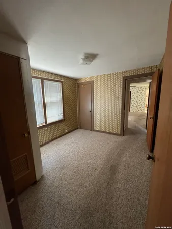 a view of an empty room with glass door and a window