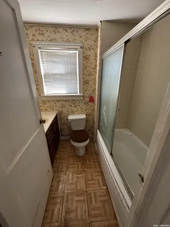 a bathroom with a granite countertop bathtub sink and toilet