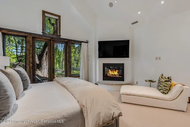 a bedroom with a bed and a large window