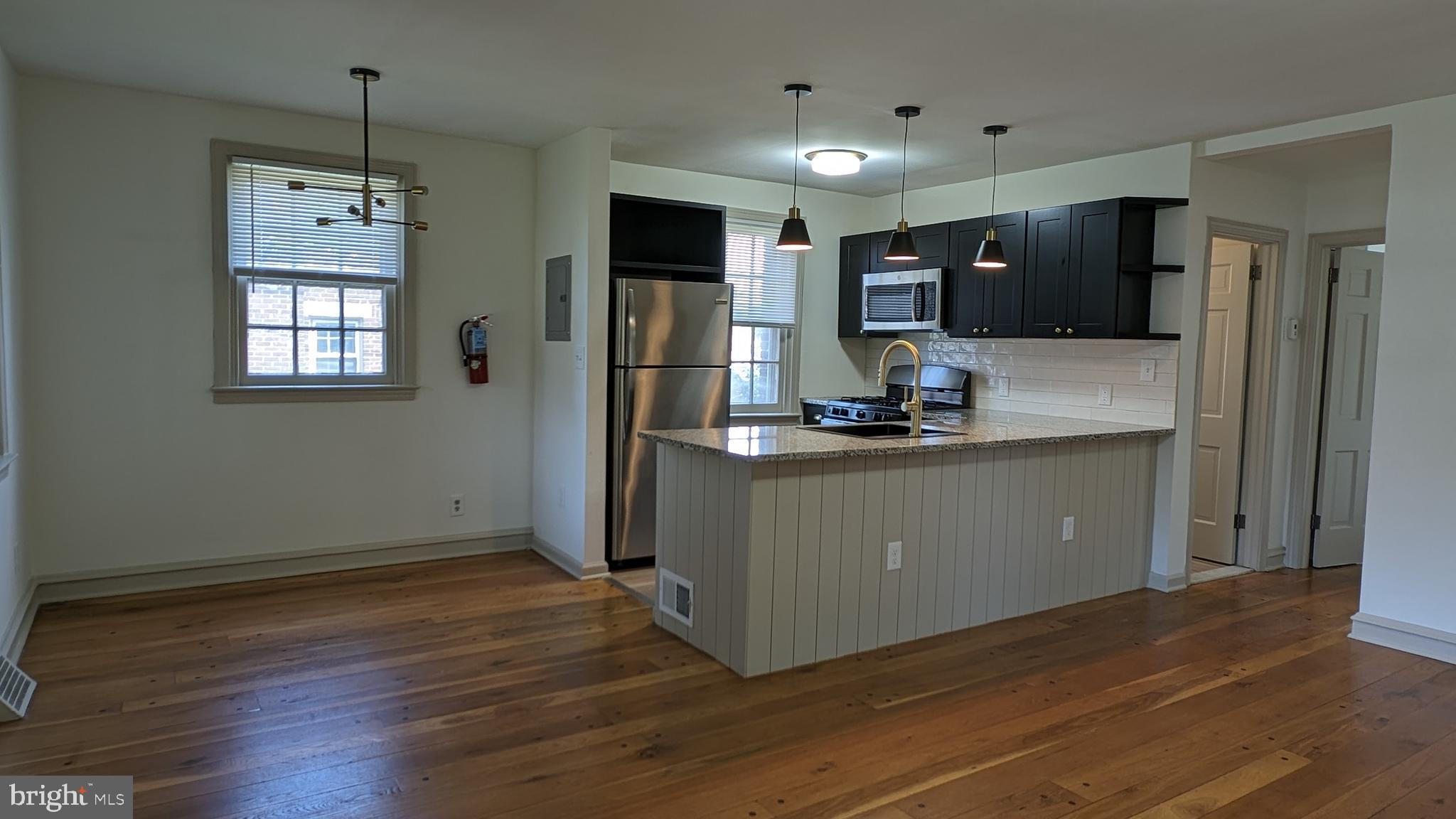 a kitchen with kitchen island stainless steel appliances a refrigerator sink and microwave