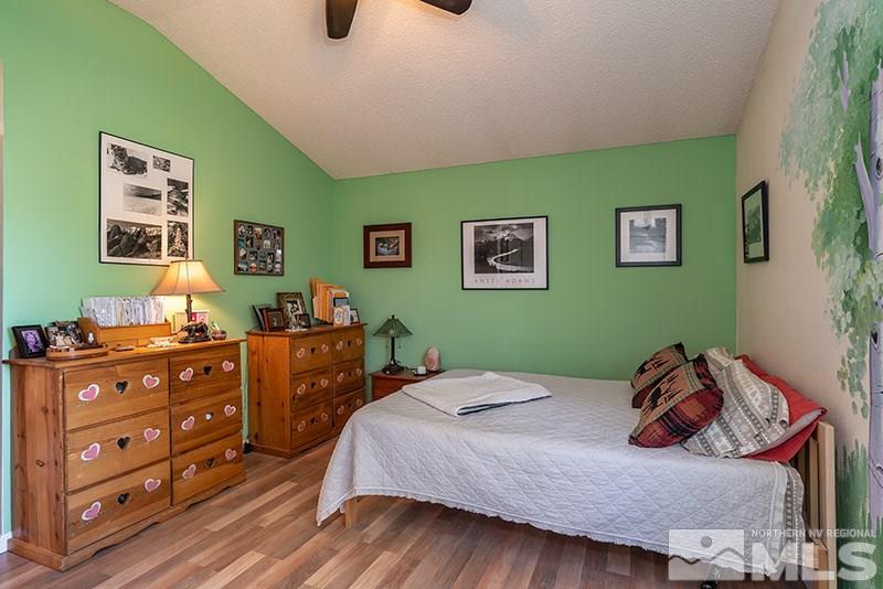 5849 Walnut Creek Road Reno, NV 89523 - Photo 13 of 20 a bedroom with a bed and wooden floor