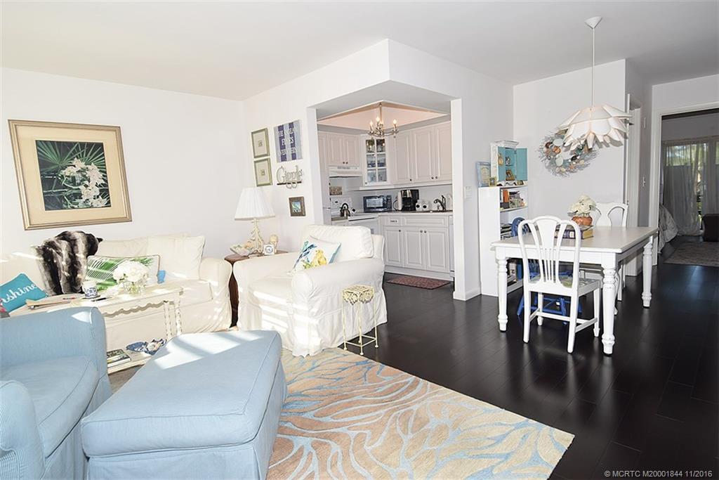 a living room with furniture wooden floor and kitchen view