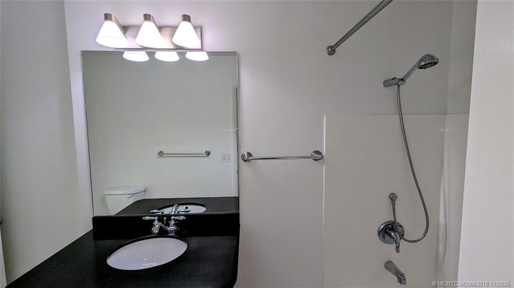 2929 Southeast Ocean Boulevard, Unit L8 Stuart, FL 34996 - Photo 5 of 32 a bathroom with a granite countertop sink mirror and vanity