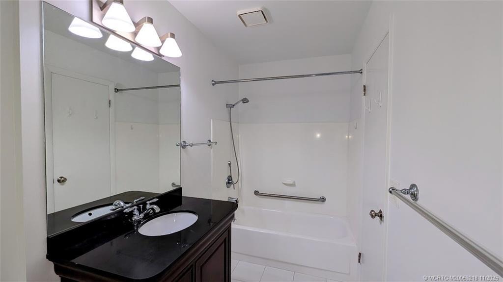 2929 Southeast Ocean Boulevard, Unit L8 Stuart, FL 34996 - Photo 6 of 32 a bathroom with a sink vanity granite and a mirror