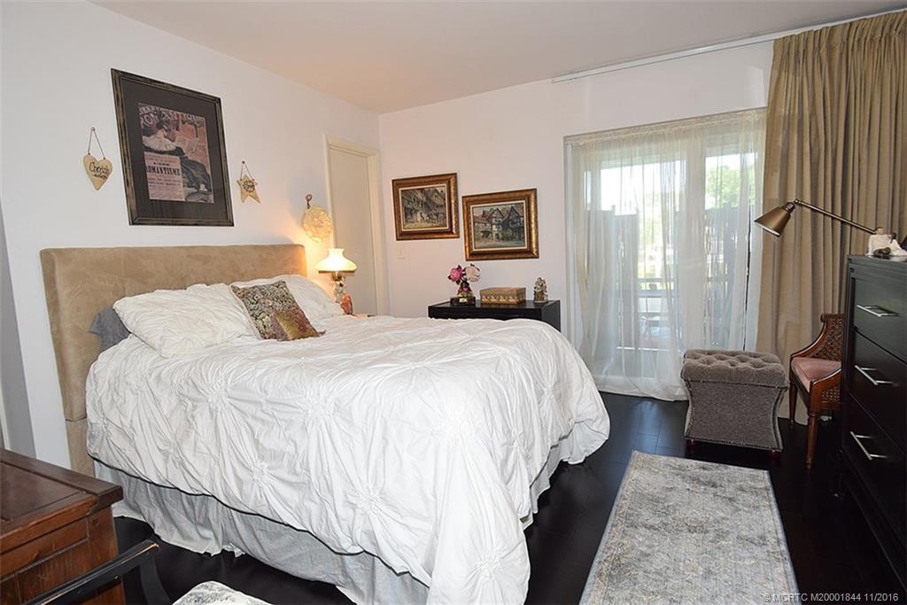 2929 Southeast Ocean Boulevard, Unit L8 Stuart, FL 34996 - Photo 7 of 32 a bedroom with a bed and a flat screen tv