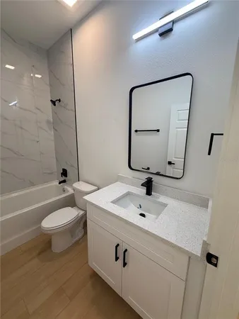 a view of empty room with wooden floor and ceiling fan