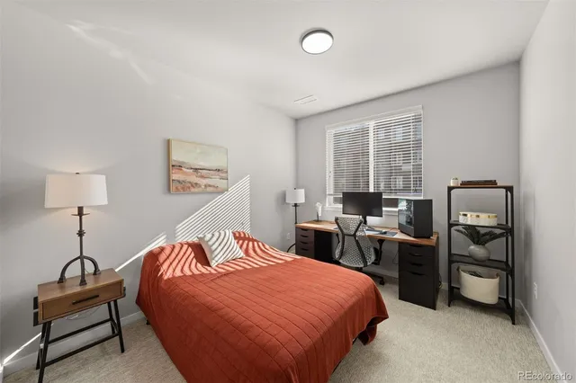 a bedroom with a bed and a desk