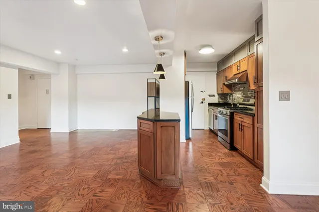 a kitchen with stainless steel appliances granite countertop a stove and a microwave