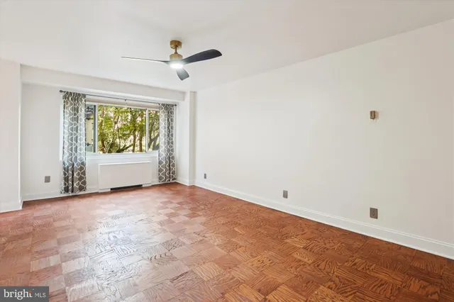 a view of empty room with wooden floor and fireplace