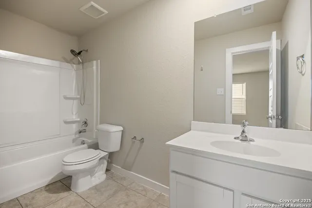 a bathroom with a toilet a sink a mirror and shower