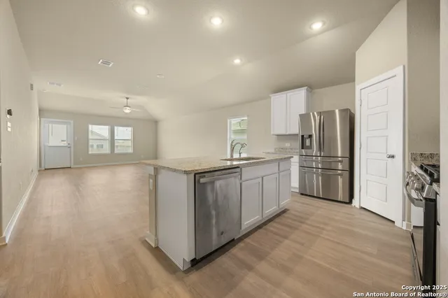 a kitchen with a refrigerator sink and cabinets