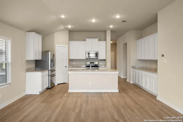 a kitchen with a refrigerator and white cabinets