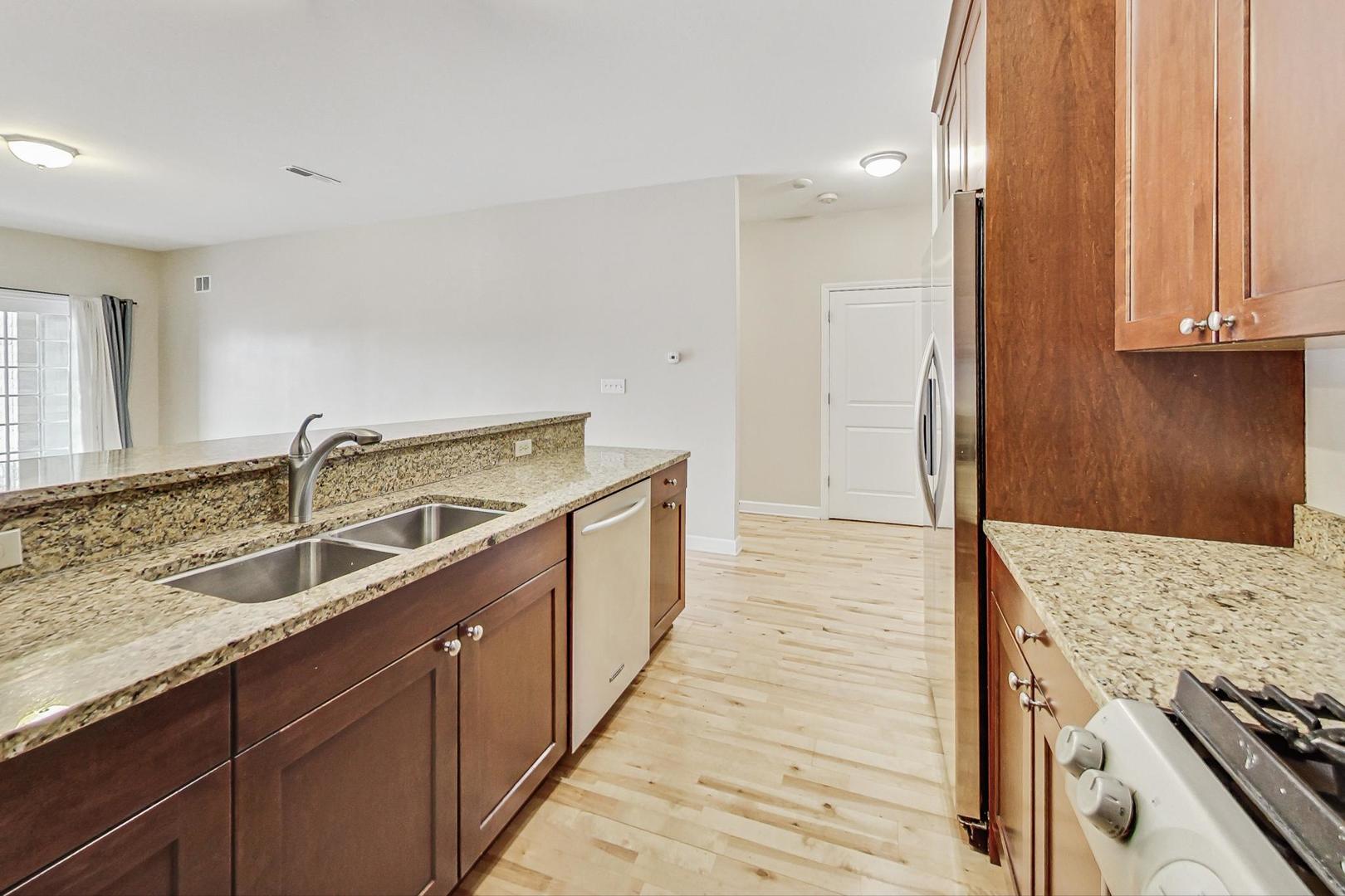 50 North Plum Grove Road, Unit 210E Palatine, IL 60067 - Photo 21 of 47 a kitchen with a sink stove and cabinets