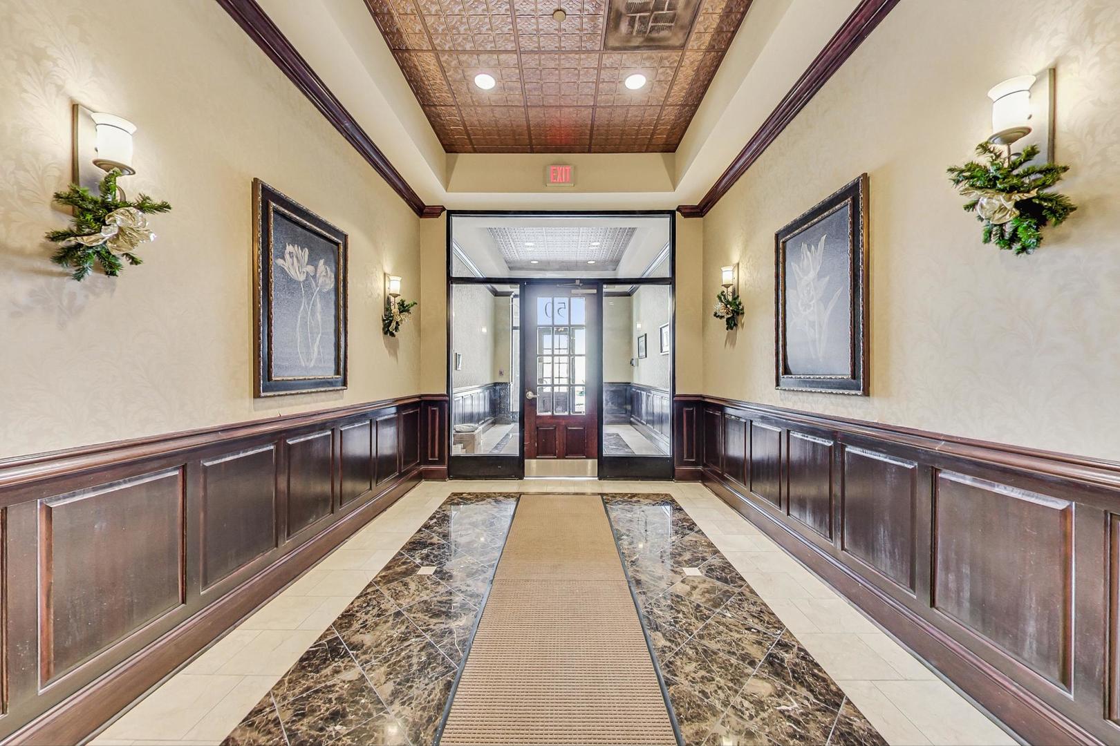 50 North Plum Grove Road, Unit 210E Palatine, IL 60067 - Photo 10 of 47 a large hall with wooden floor and chandelier