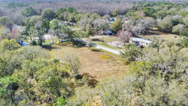an aerial view of residential house with pool and trees