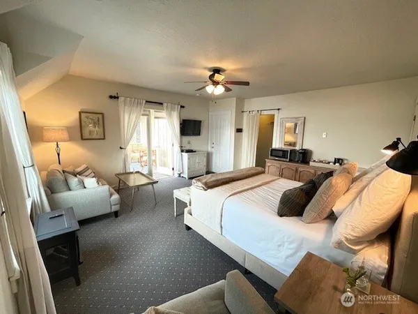 a bedroom with bed couch and window