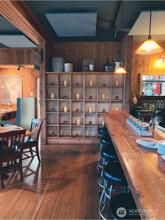 a dining room with wooden floor table and chairs