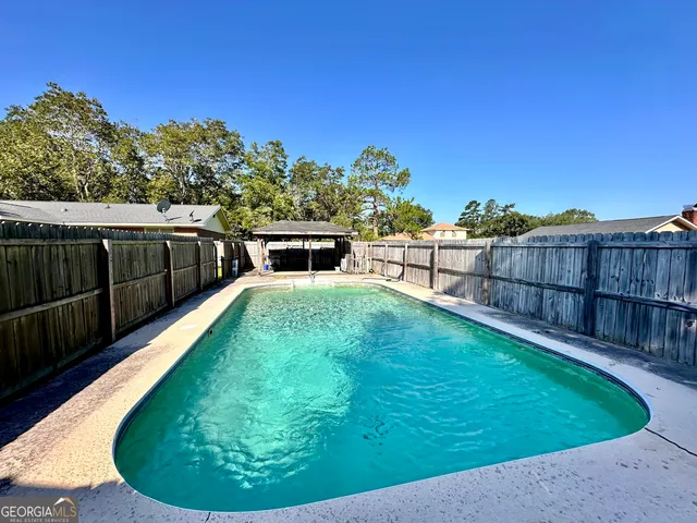 a view of a backyard with a swimming pool