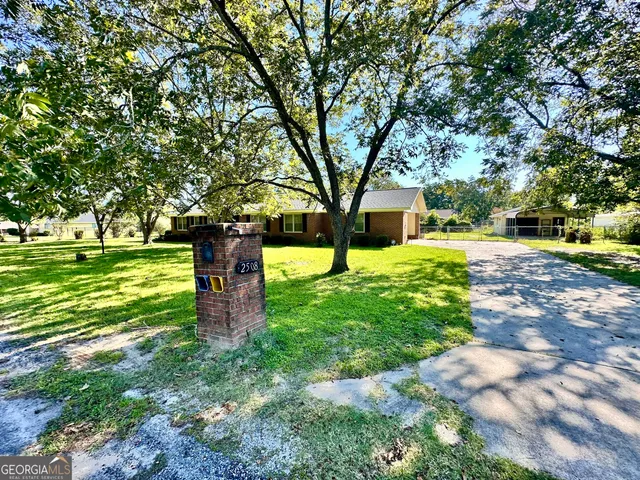 a front view of a house with a yard and tree