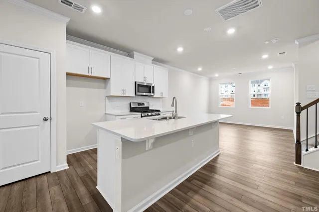 a view of kitchen with sink and refrigerator