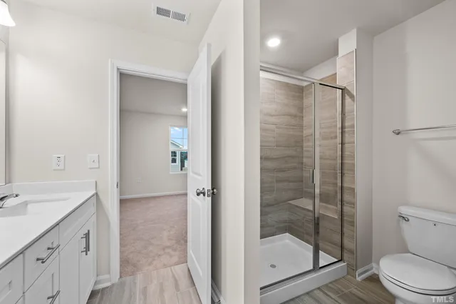 a bathroom with a shower a sink a toilet and a mirror