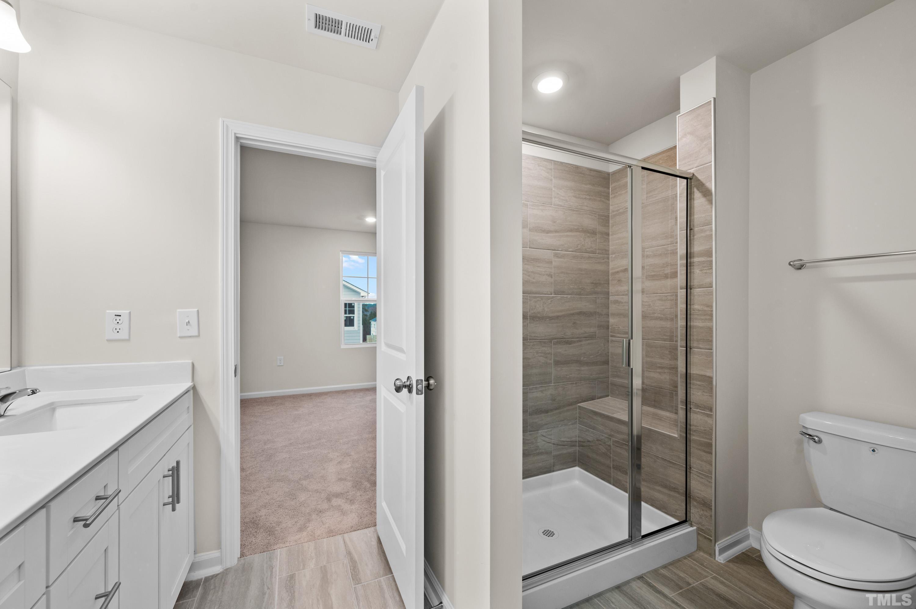 414 Odham Lane Wake Forest, NC 27587 - Photo 19 of 29 a bathroom with a shower a sink a toilet and a mirror