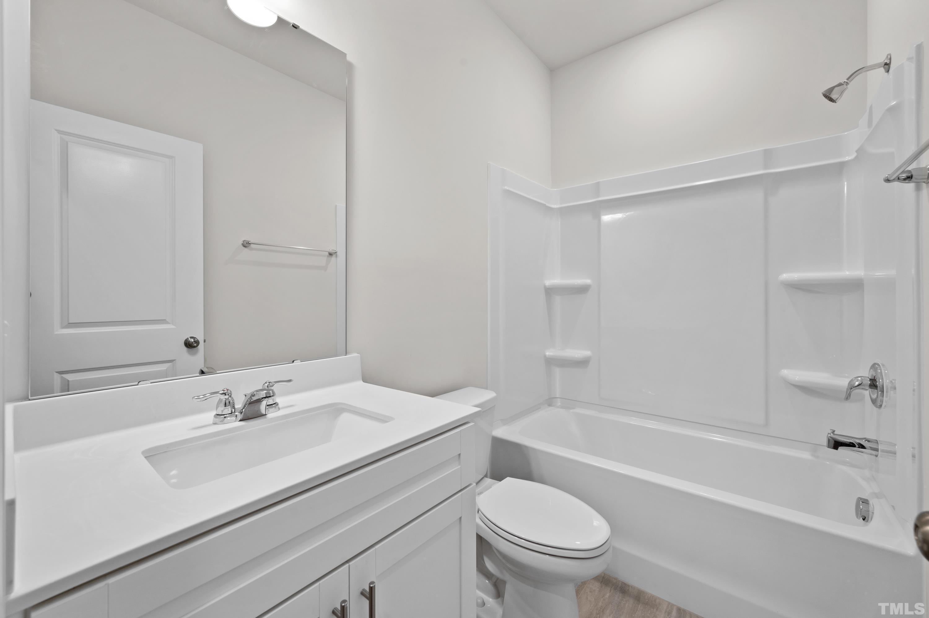 414 Odham Lane Wake Forest, NC 27587 - Photo 4 of 29 a bathroom with a sink a toilet and a bathtub