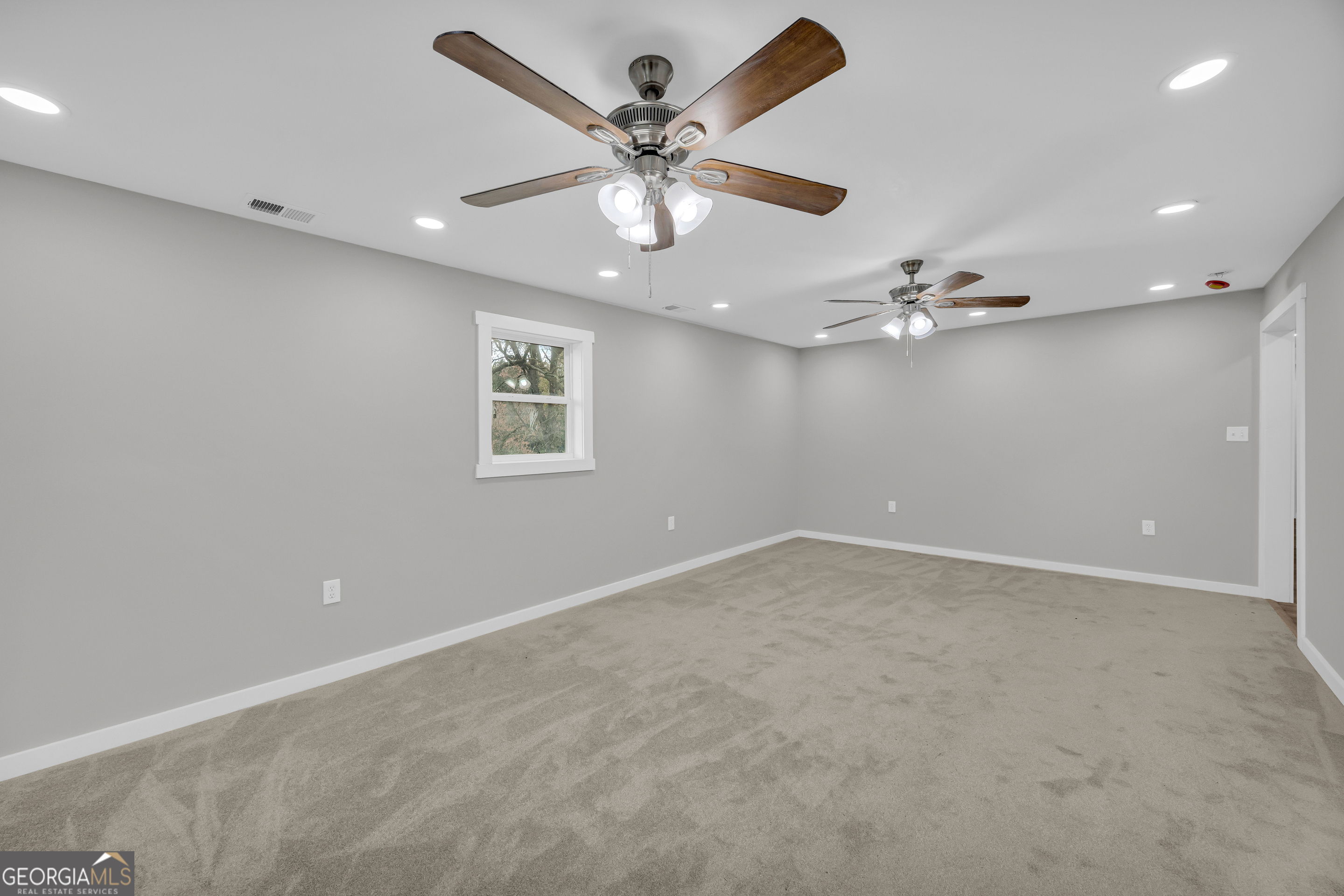 8606 Holly Springs Road Maysville, GA 30558 - Photo 49 of 74 an empty room with a ceiling fan and a window